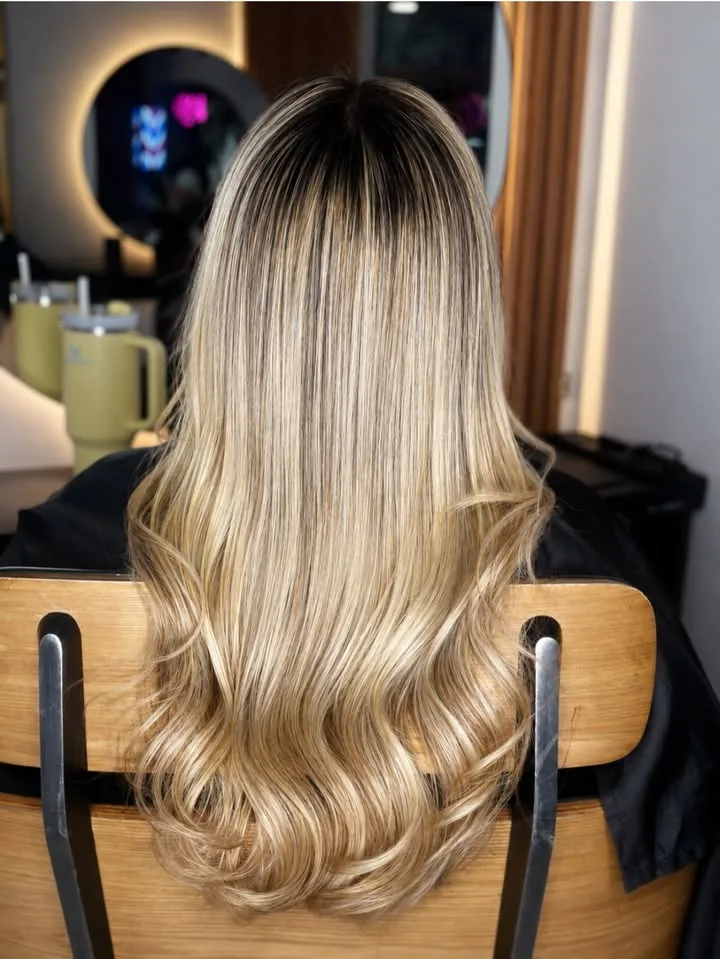 Cabello largo rubio con raíz oscura y ondas suaves visto de espaldas
